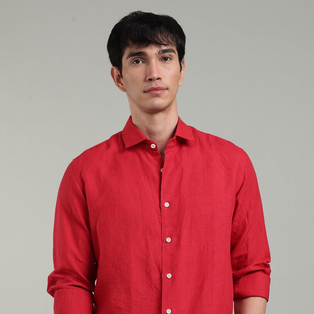 Man wearing a red linen shirt against a gray background