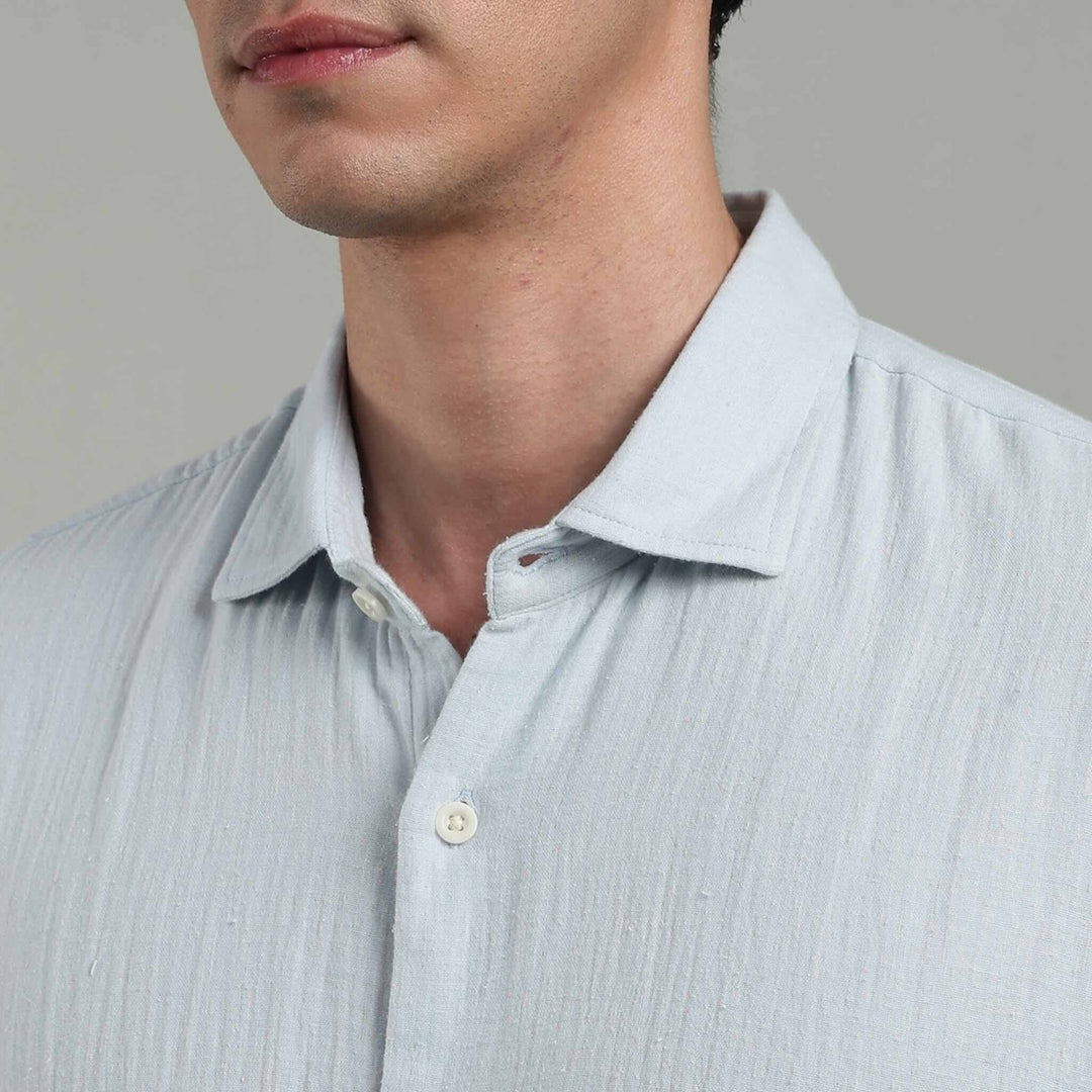 Light blue  shirt worn by a person on a gray background