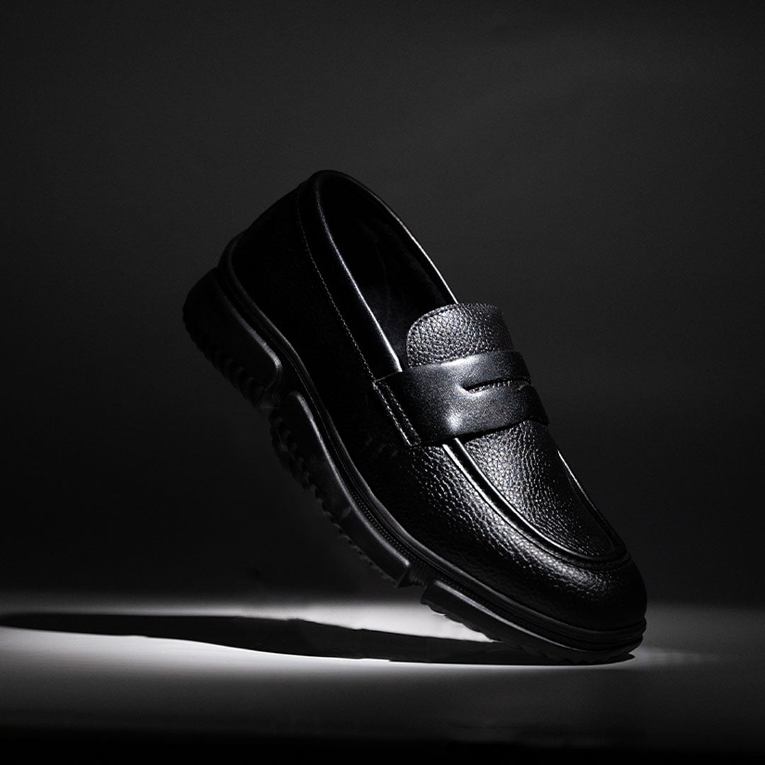 Black loafer shoe on a dark background