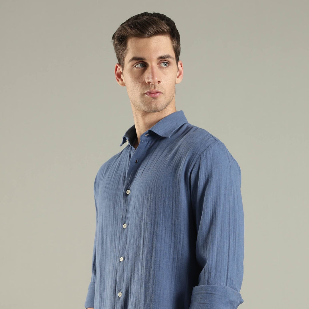 Man wearing a blue shirt against a plain background