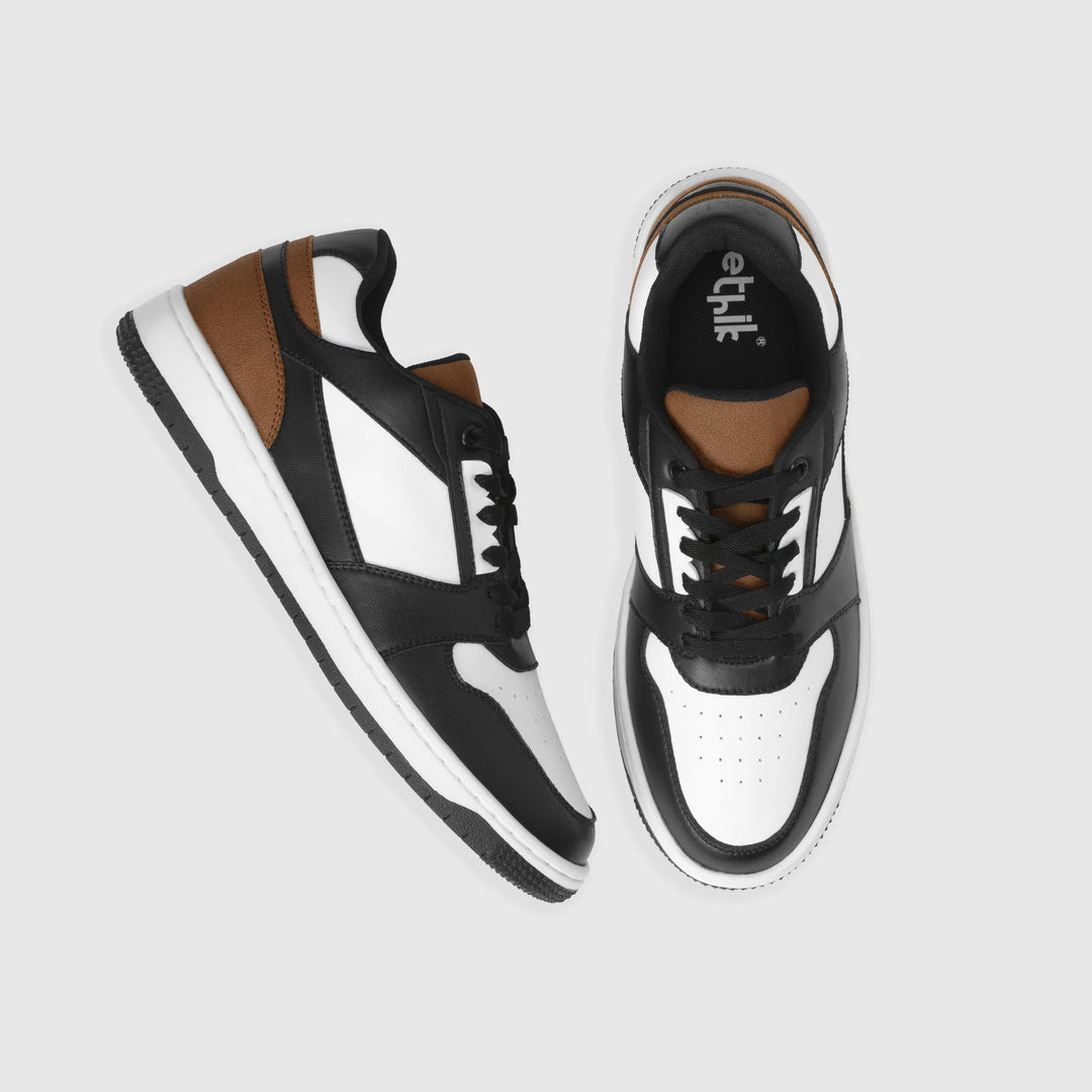 Black and white sneakers with brown accents on a light gray background