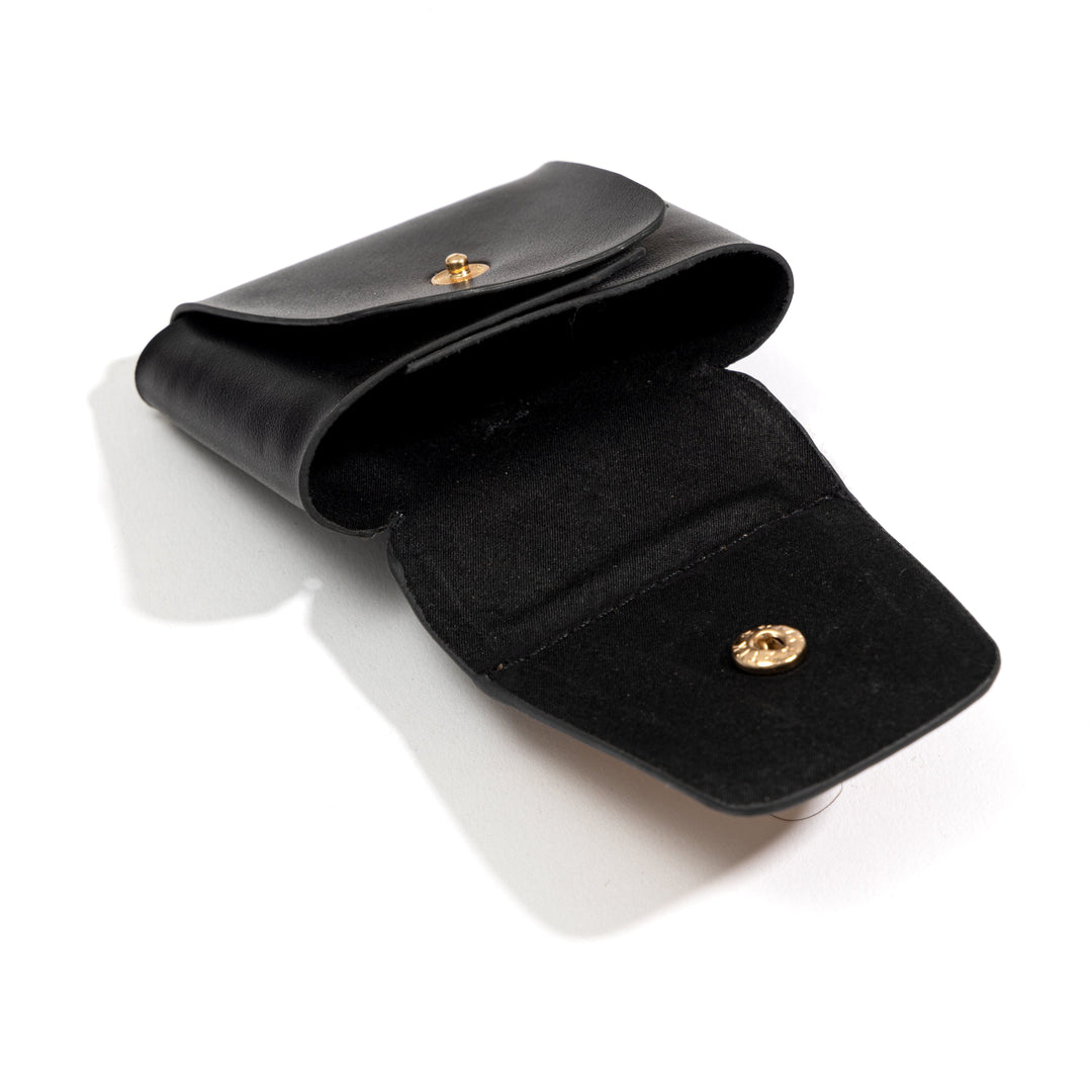 Open plant leather AirPods cover from the Noir Holiday Travel Set by Green Hermitage showing snap button closure and interior compartment