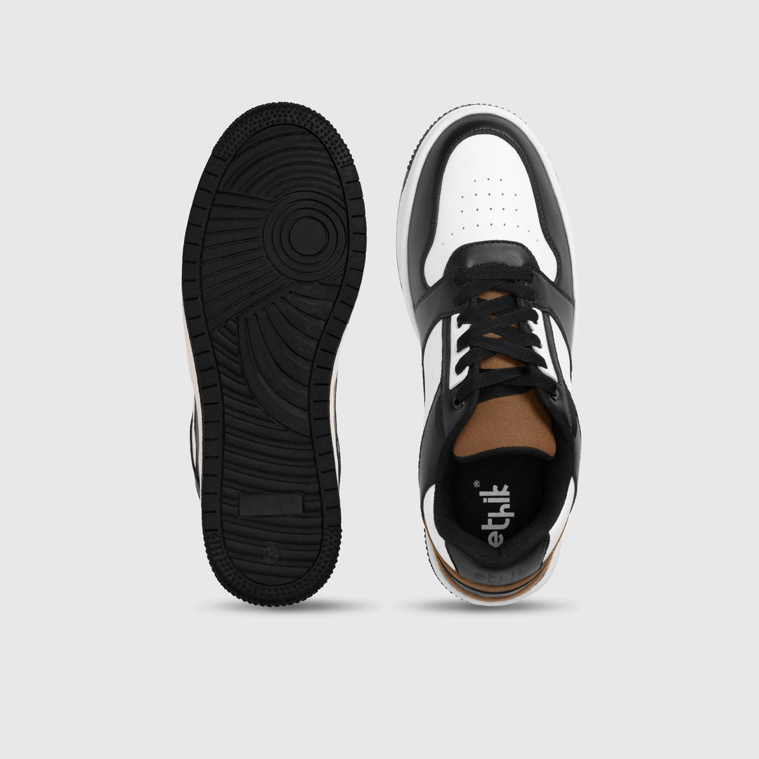 Black and white sneaker with sole showing brand logo on a light gray background